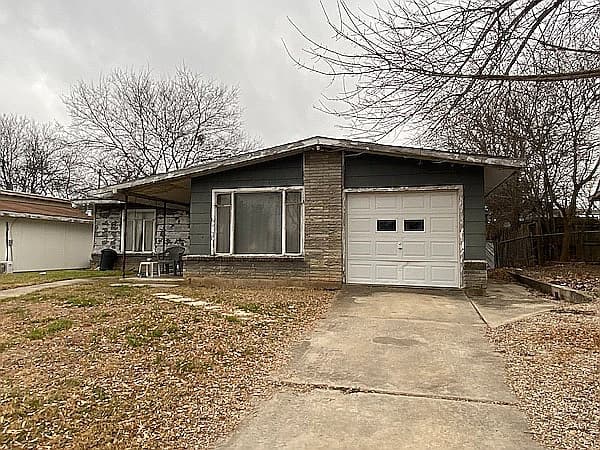 Before picture 1 - Exterior front view showing peeling paint and damaged siding