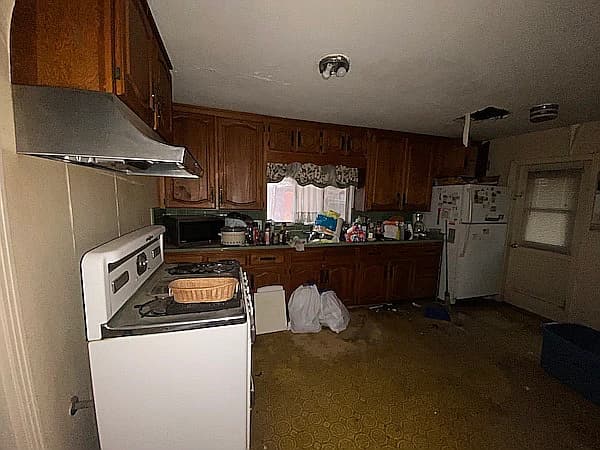 Before picture 3 - Kitchen view showing outdated appliances and water damage