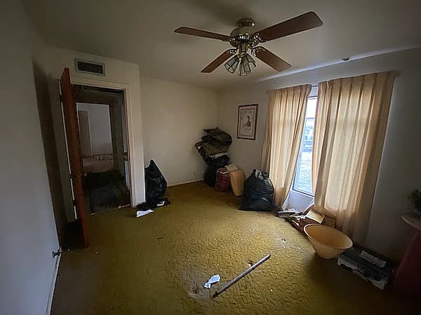 Before picture 5 - Primary bedroom view showing outdated and worn carpet