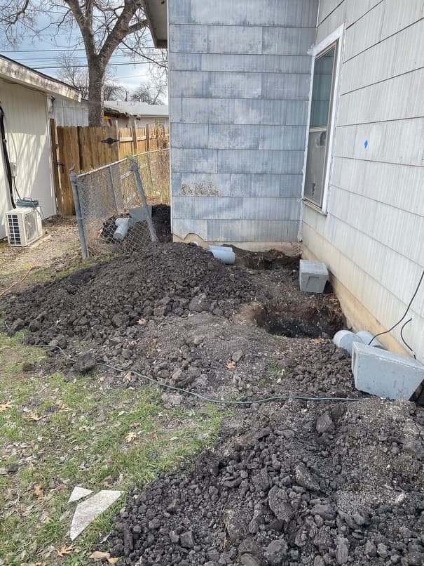 Holes dug to lift side of the house to correct 3 inch slope over 15 foot span