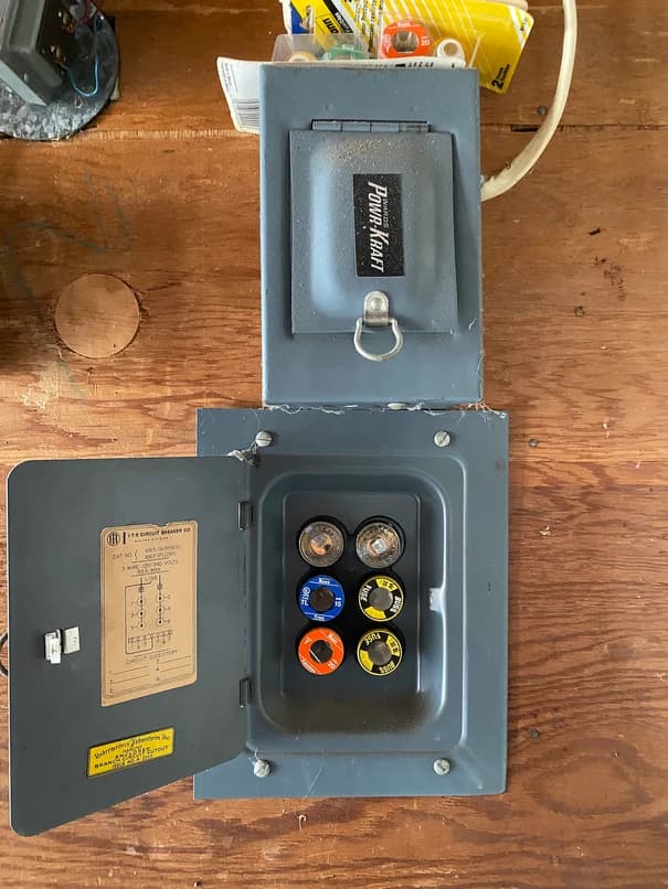 Fuse box in the garage showing outdated wiring and lack of safety features