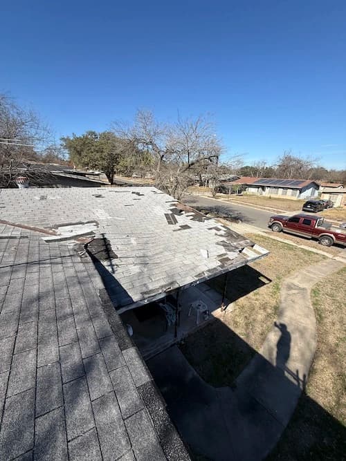 View of roof showing tons of missing shingles and exposed decking